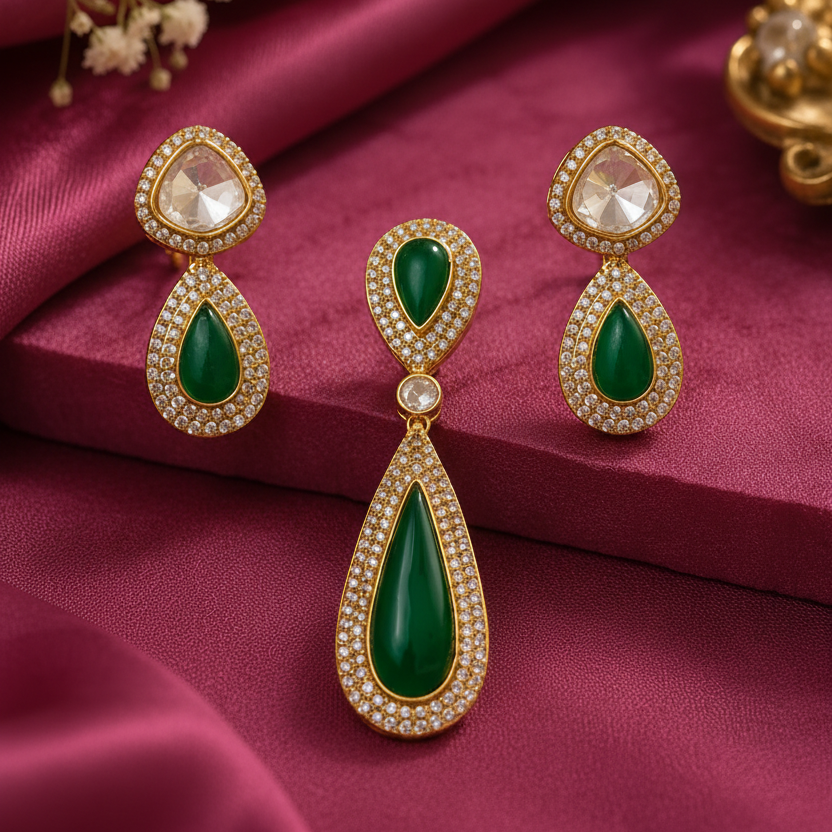 emerald green teardrop pendant and matching earrings set with gold-tone settings, sparkling white Kundan-style stones and elegant bridal jewellery design by Evah Jewels.