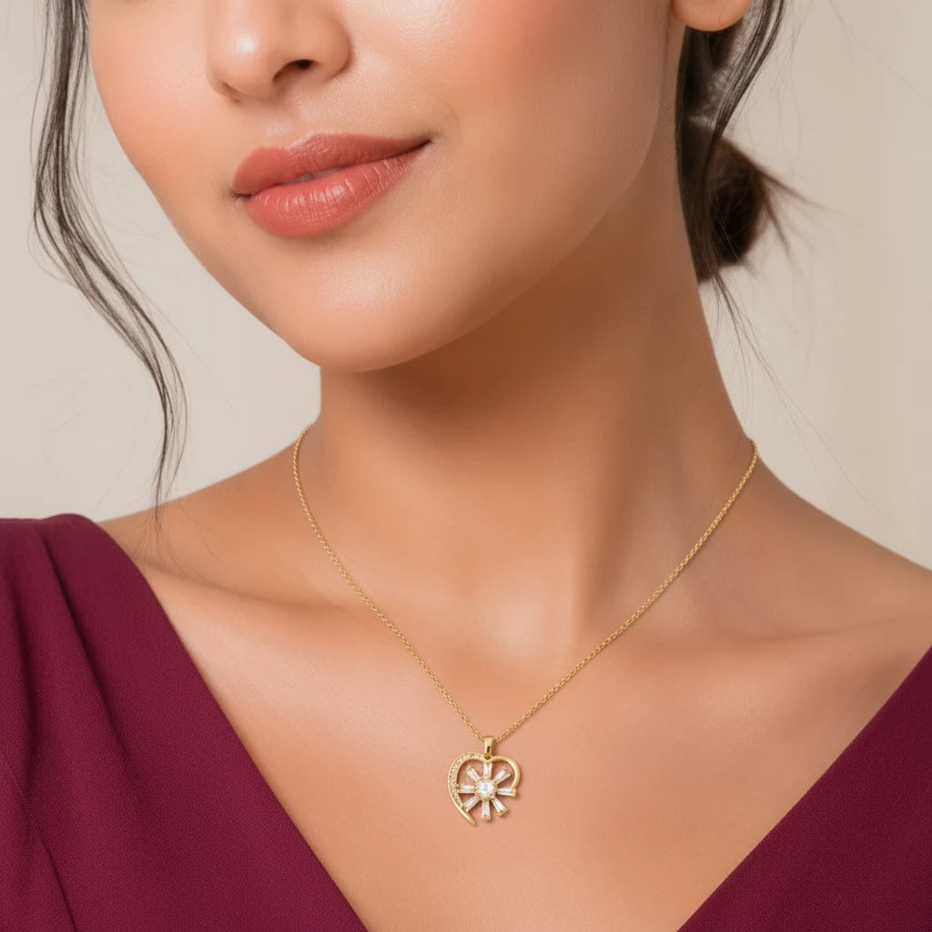 Woman wearing EVAH JEWELS gold plated sunburst heart pendant necklace with sparkling white stones, delicate gold-tone chain and elegant floral heart design, styled with a burgundy outfit.