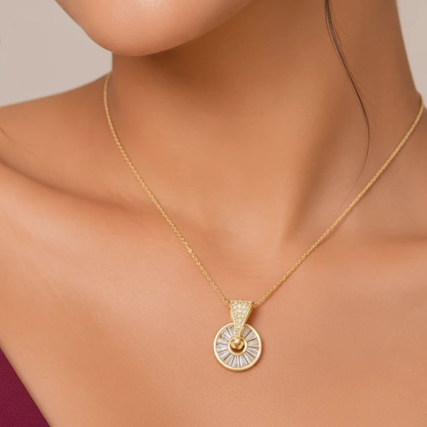 Elegant gold plated Sunburst Wheel Pendant Necklace for Women featuring a circular design with sparkling baguette-cut stones and a crystal-studded bail, displayed on luxurious pink satin fabric. Shop stylish anti-tarnish fashion jewellery online in India at EVAH JEWELS.