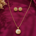 gold-tone floral pendant necklace and matching stud earrings set for women, featuring round white enamel-style detailing, delicate rose designs and sparkling crystal accents on burgundy satin by Evah Jewels.