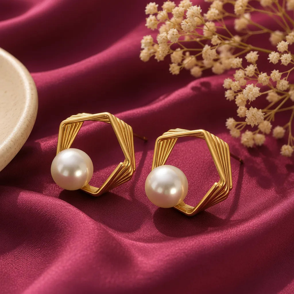 gold-tone geometric hexagon pearl stud earrings for women, featuring layered open-frame designs and elegant white pearl accents on burgundy satin by Evah Jewels.
