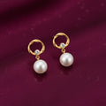 gold-tone circular pearl drop earrings for women featuring elegant open-circle studs, sparkling solitaire crystal accents and dangling white pearl beads, displayed on a luxurious burgundy background by Evah Jewels.