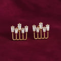 gold-tone geometric baguette crystal stud earrings for women featuring five sparkling rectangular clear stones arranged at varying heights in an elegant open-frame design, displayed on luxurious burgundy velvet fabric by Evah Jewels.