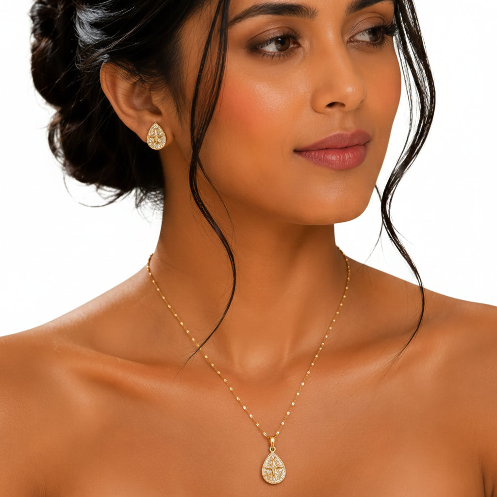 Model wearing EVAH JEWELS gold-tone teardrop pendant necklace and matching crystal-studded earrings for women, featuring elegant star-inspired designs.