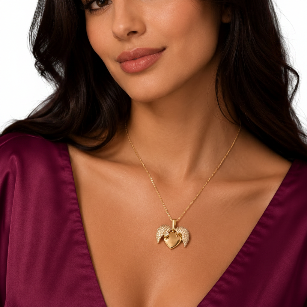 Gold-tone imitation jewellery necklace with a heart-shaped pendant, sparkling wing details, and a heart accent by Evah Jewels