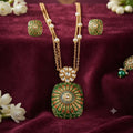 traditional green Meenakari pendant necklace set with gold-tone double-layer chain, pearl accents, floral Kundan-style detailing and matching green stud earrings by Evah Jewels.