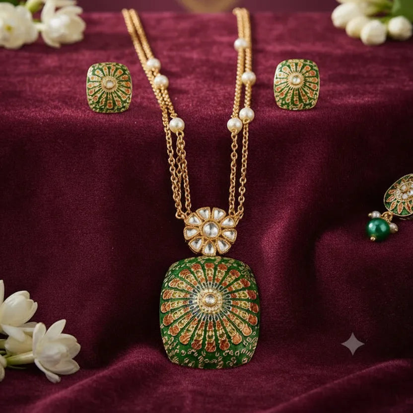 traditional green Meenakari pendant necklace set with gold-tone double-layer chain, pearl accents, floral Kundan-style detailing and matching green stud earrings by Evah Jewels.