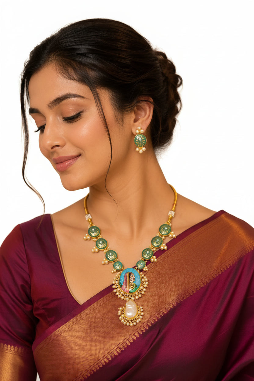 EVAH JEWELS traditional green Meenakari necklace set with Rajasthani portrait pendant, pearl detailing and matching earrings, styled on a woman wearing a maroon silk saree.