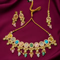 gold-tone multicolour Kundan necklace set with pastel stones, sparkling crystal borders, green enamel details, dangling beads and matching earrings on burgundy satin by Evah Jewels.