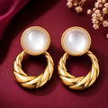 old-tone pearl twisted hoop drop earrings for women featuring glossy round white pearl-like studs and bold textured gold circular drops, displayed on luxurious burgundy fabric by Evah Jewels.