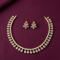 gold-tone pastel pink and mint green teardrop stone necklace set with matching floral stud earrings, featuring sparkling crystal accents on burgundy fabric by Evah Jewels.